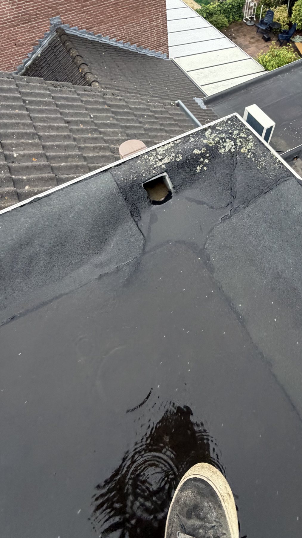 Slechte afvoer met zichtbaar stilstaand water op een plat dak